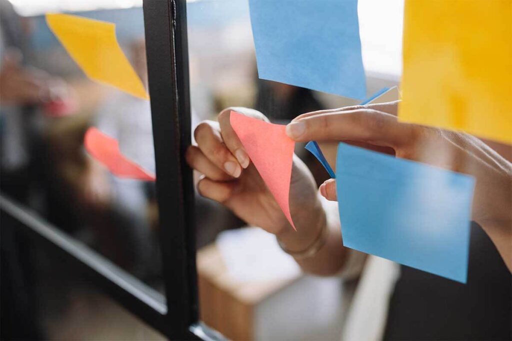 Person putting post-it notes on window