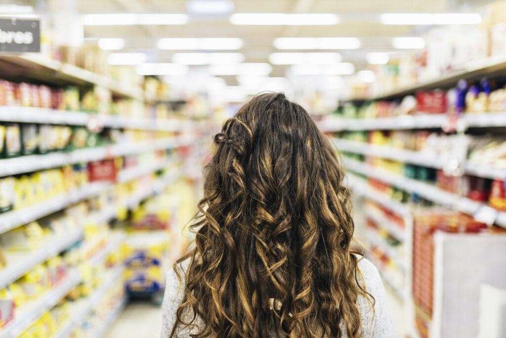 Back View Of Beautiful Woman Buying Food In Supermarket.