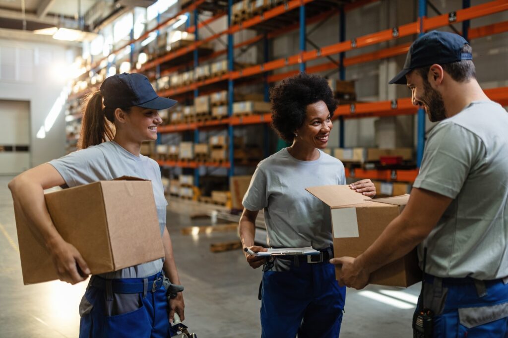 Employees in warehouse smiling at each other
