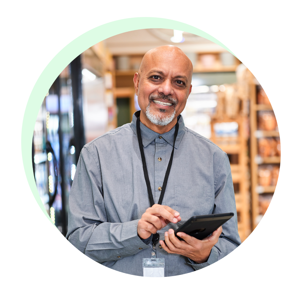 Smiling grocery associate holding a mobile device