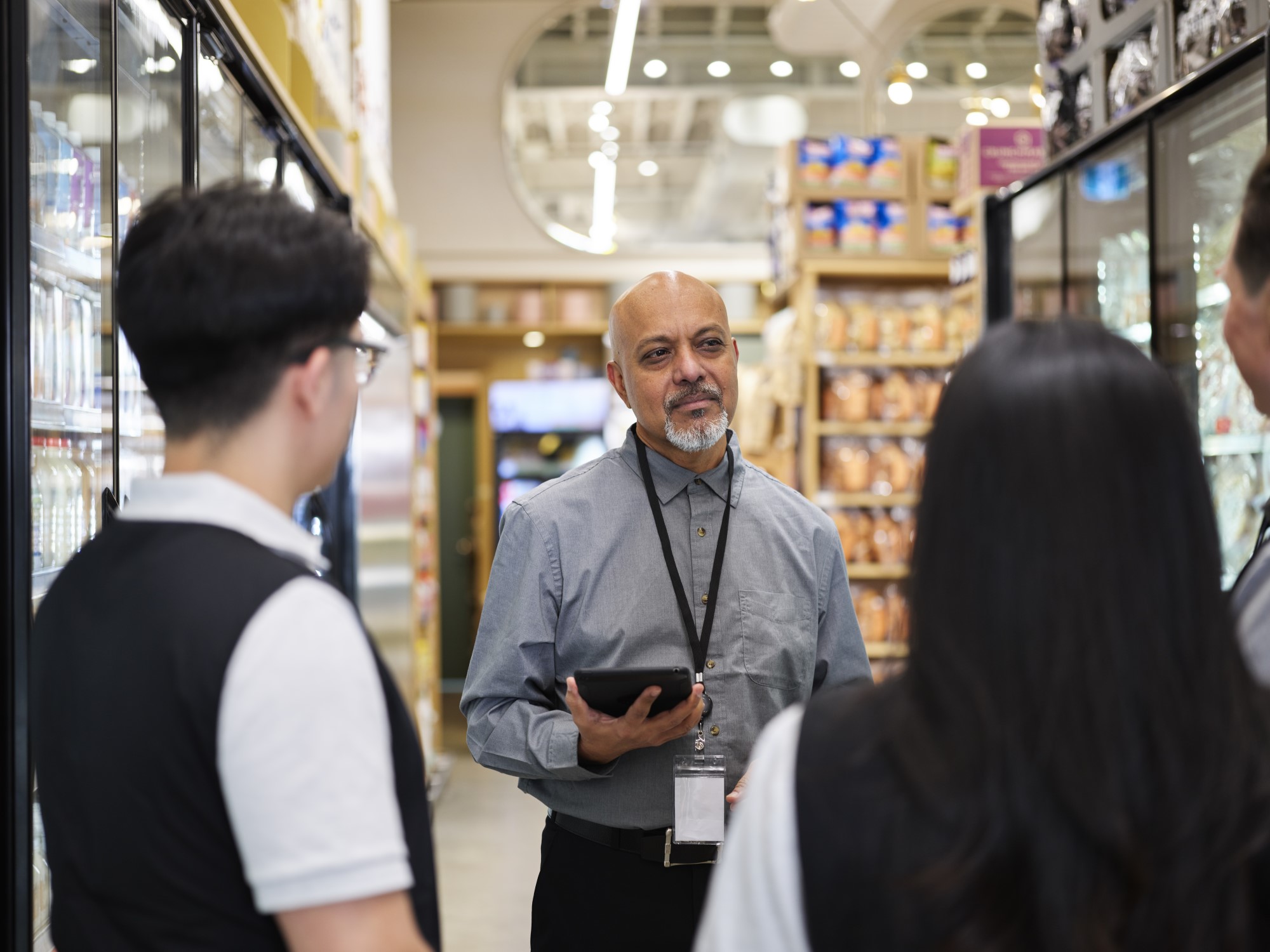 A grocery manager speaking to a group of associates