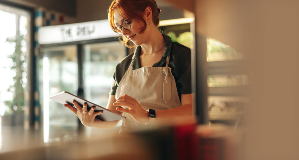 Retail manager Using A Digital Tablet In Her Grocery Store for operations.