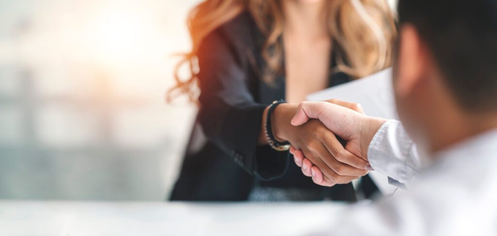Business leaders shaking hands, building trust in L&D