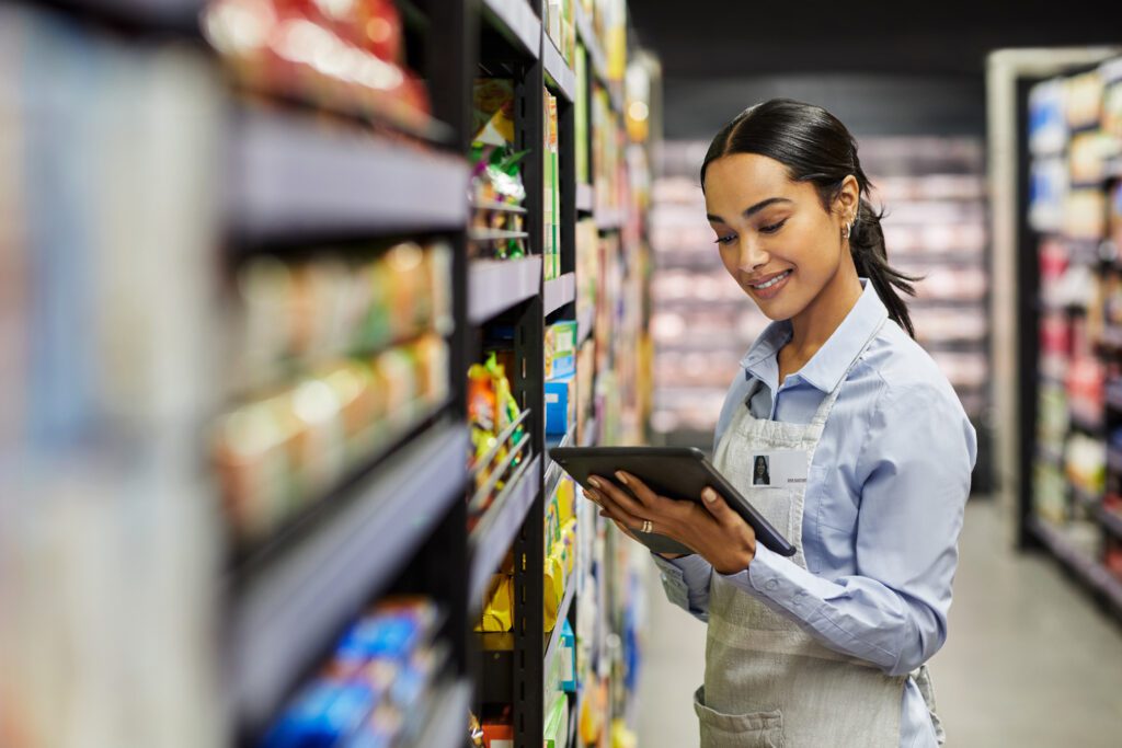 Shot Of A Young Woman Using A Tablet At Work In A Supermarket