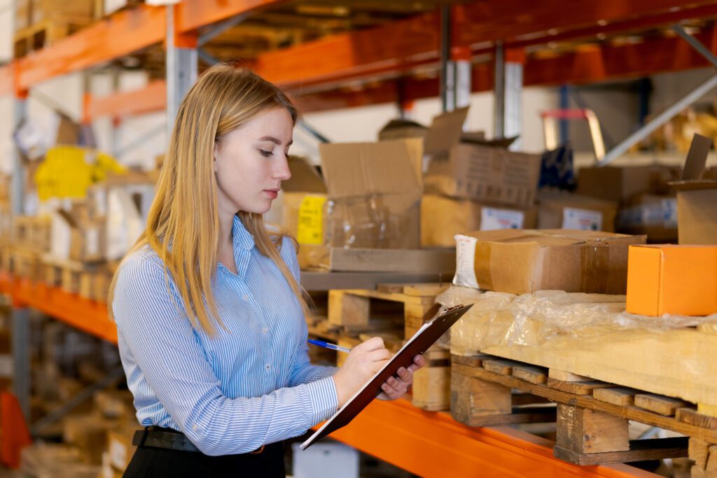 Focused Female Logistics Manager Auditing Stock In Warehouse