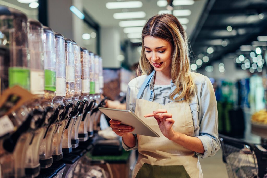 Woman Working At A Grocery Store And Using Tablet