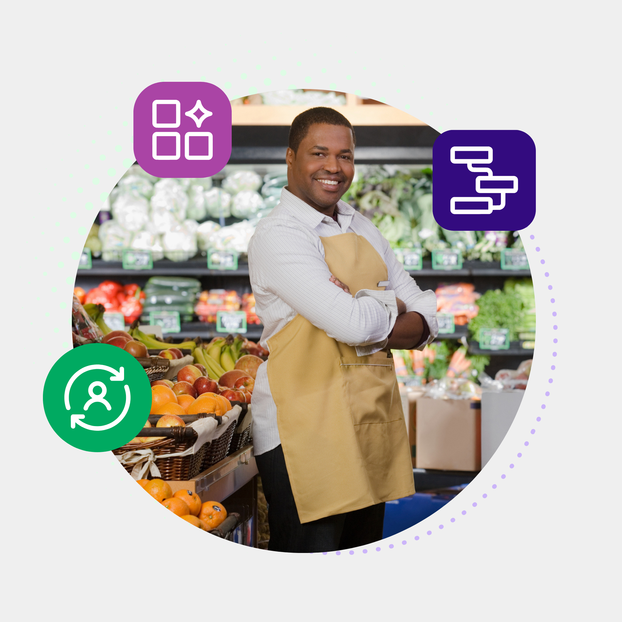 A smiling grocery clerk in an apron standing with arms crossed in front of a fresh produce display